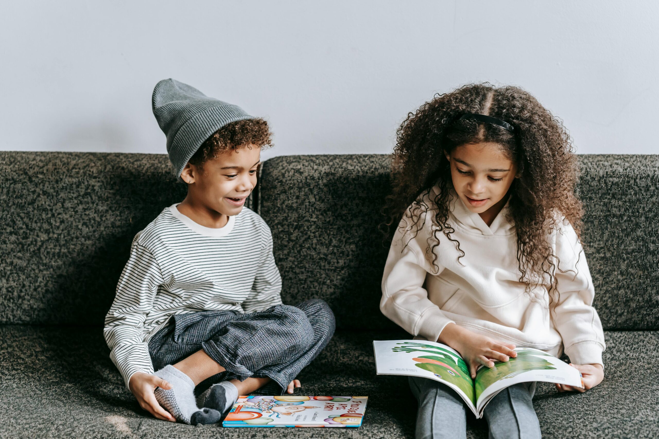 🧠 100+ “Why” Questions for Kids to Spark Curiosity Siblings reading a picture book together indoors, fostering a love of literature.