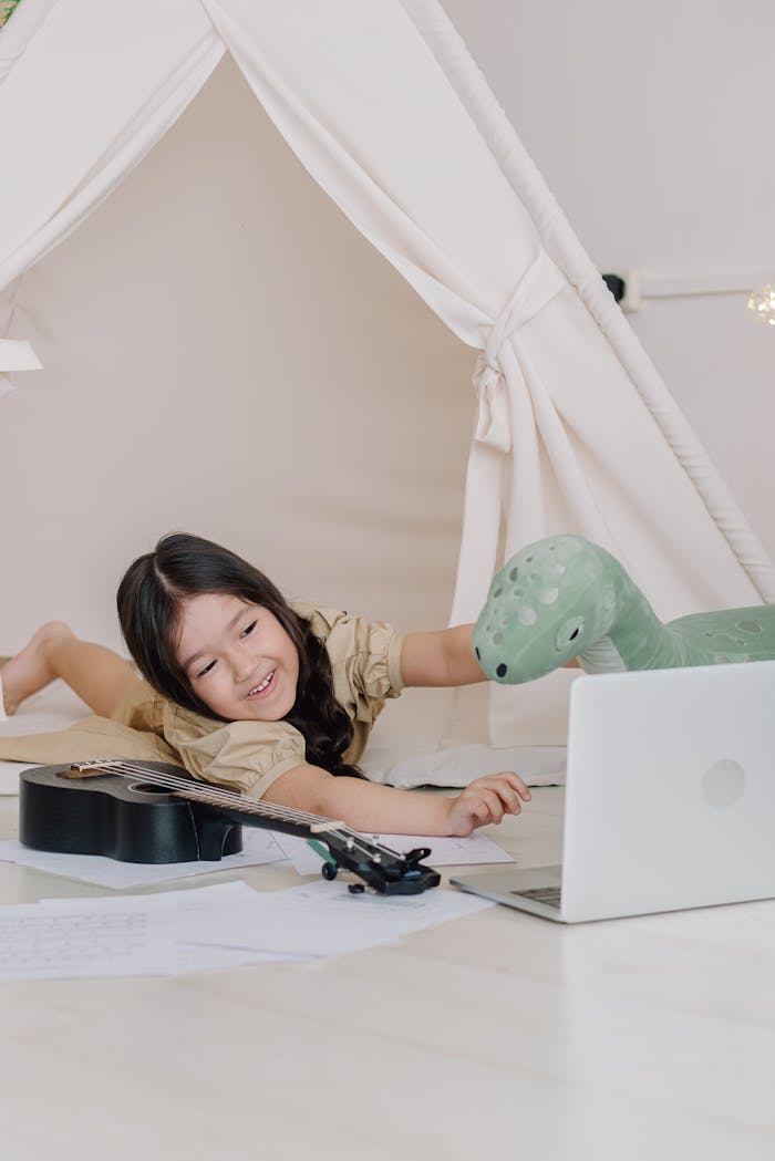 🧠 Homeschooling 360 view: The Ultimate Guide to Personalized Learning A happy child with a ukulele video chatting in a cozy indoor tent space.